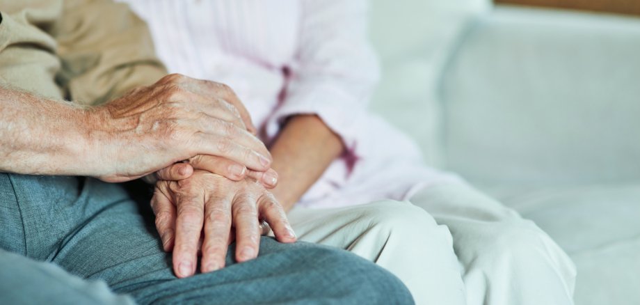 Cropped photo of elderly man holding hands of his wife