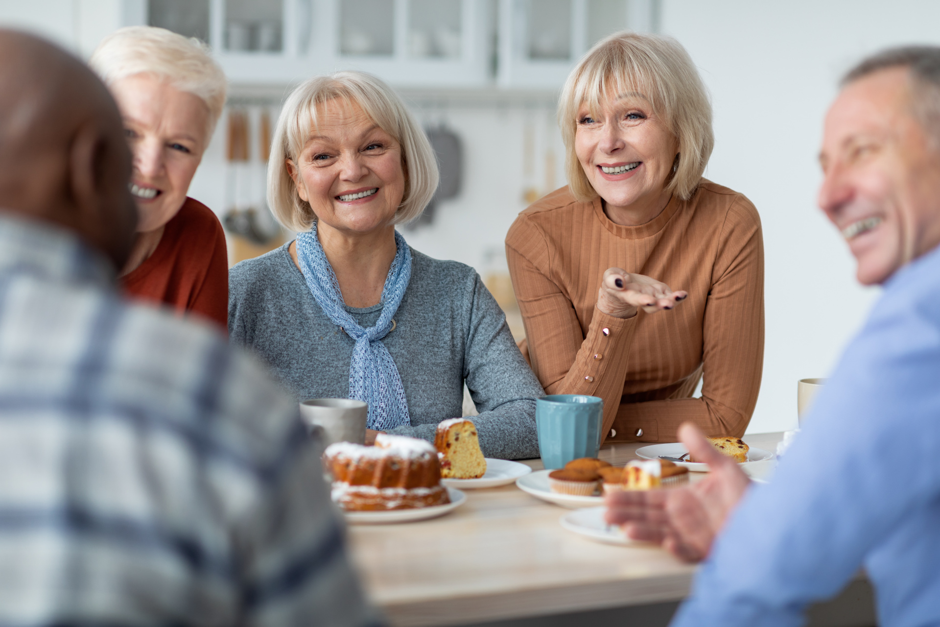 Eine gemischte Gruppe Menschen bei Kaffee und Kuchen.