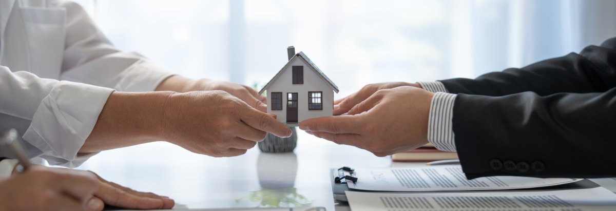 Zwei Hände die ein Haus halten