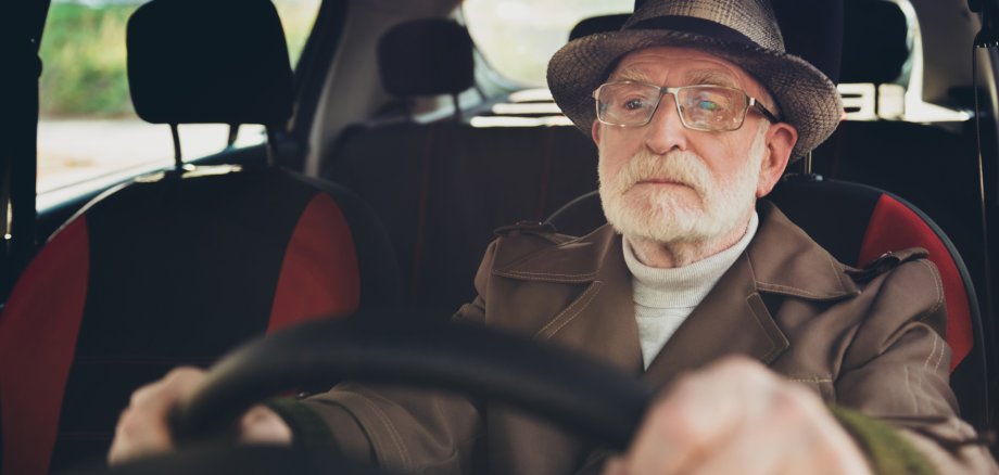 Ein älterer Herr am Steuer eines Autos