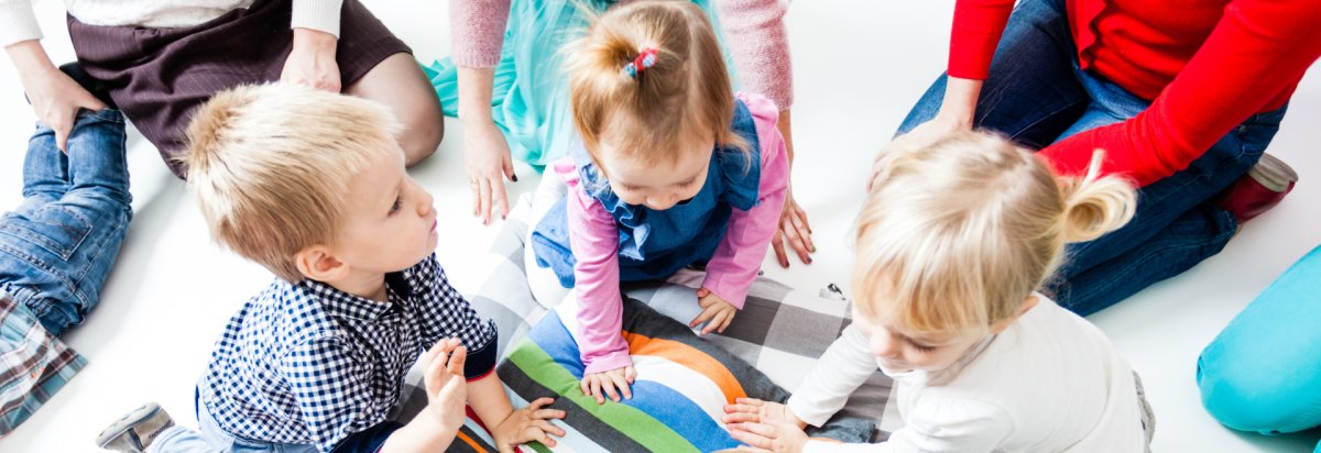 Fünf spielende Kleinkinder im Kreis versammelt