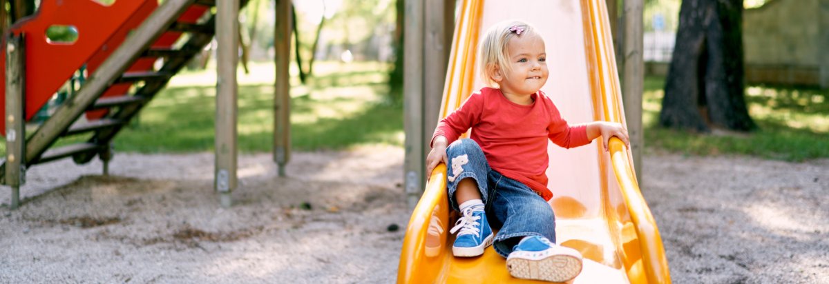 Ein Kind auf einem Spielplatz das rutscht