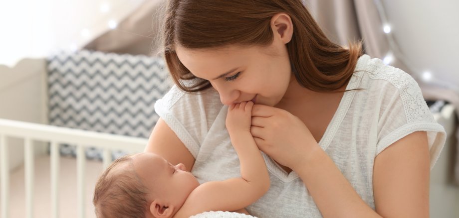 Frau mit Baby Eine Mutter mit ihrem Neugeborenen zuhause.