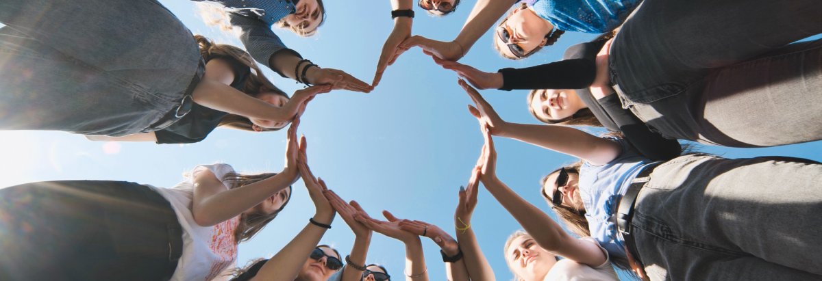 Menschen die mit ihren Händen ein Herz bilden