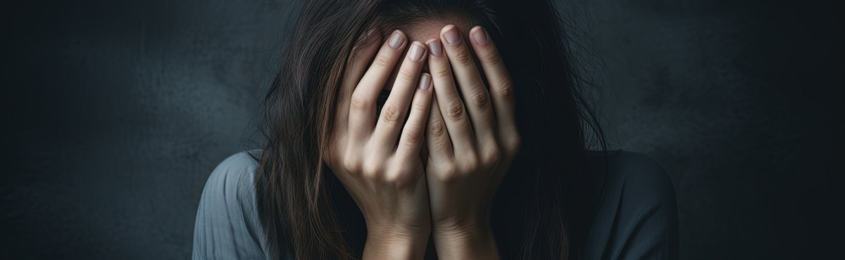 Eine Frau die verzweifelt die Hände vor dem Gesicht hält