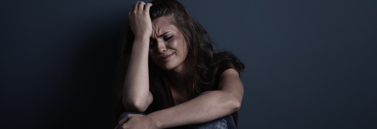 Eine verzweifelte Frau die am Boden sitzt