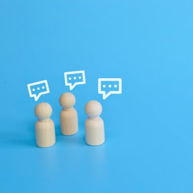 Drei Holzfiguren mit Gedankenblasen