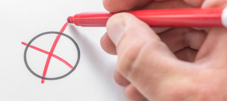 Eine Hand die ein Wahlkreuz in rot zeichnet