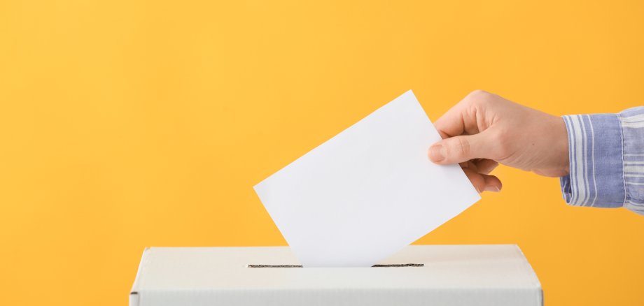 Voting woman near ballot box on color background