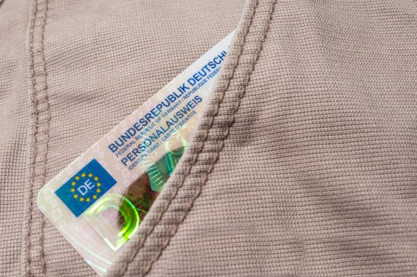Ein deutscher Personalausweis ragt aus einer Hosentasche.