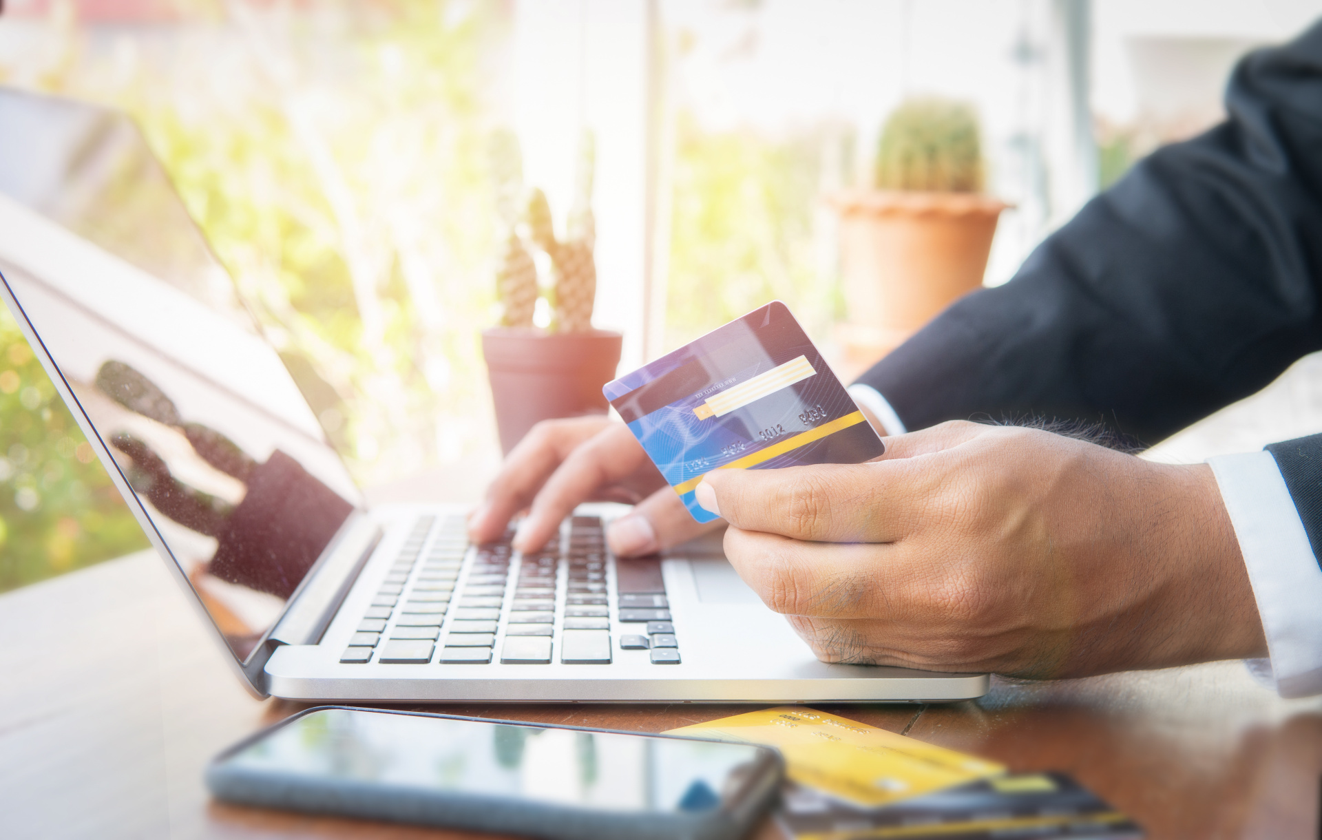 Eine Person die eine finanzielle Überweisung mit einer Kreditkarte in der Hand tätigt