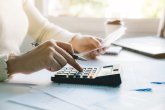 women calculate domestic bills at home. using calculator at mode women calculate domestic bills at home. using calculator at mode