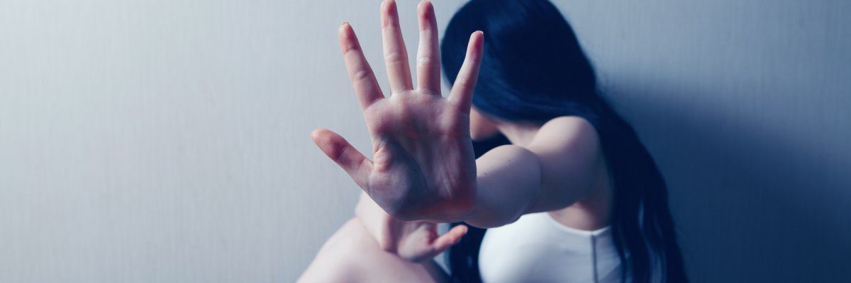 Ein Mädchen dass sich zur Wand abgewand hat und den Arm ausstreckt