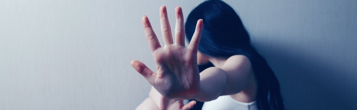 Ein Mädchen dass sich zur Wand abgewand hat und den Arm ausstreckt