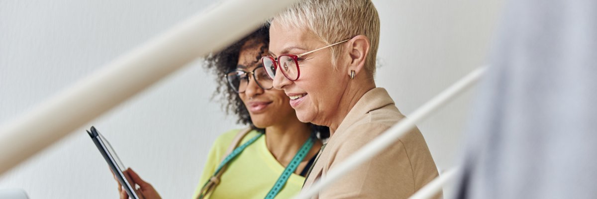 Zwei Damen die auf ein Tablet schauen