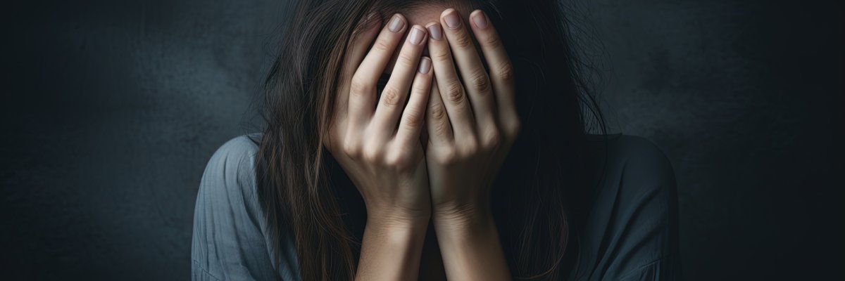 Eine Frau die verzweifelt die Hände vor dem Gesicht hält