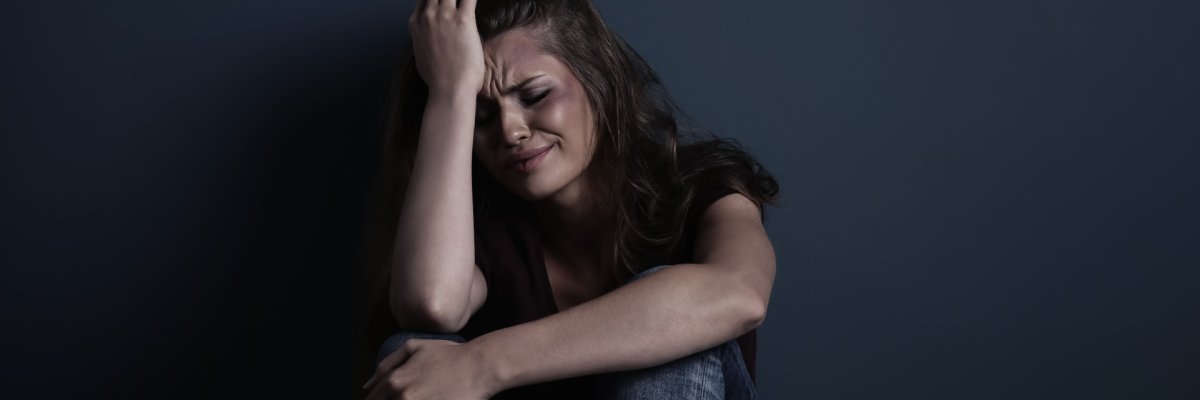 Eine verzweifelte Frau die am Boden sitzt