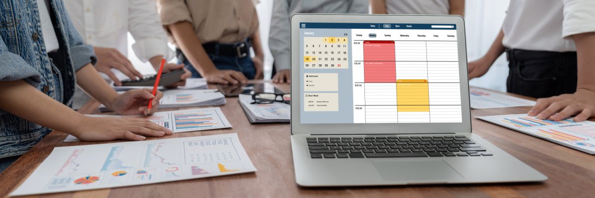 Teambesprechung mit mehreren Personen die um einen Tisch herum stehen