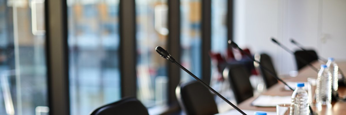 Business objects on table Besprechungssaal mit Mikrofonen und Wasser auf dem Tisch