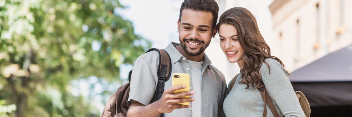 2 Personen die auf ein Handy schauen