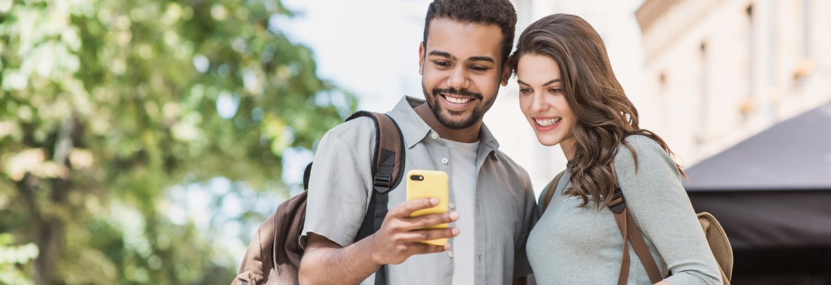2 Personen die auf ein Handy schauen