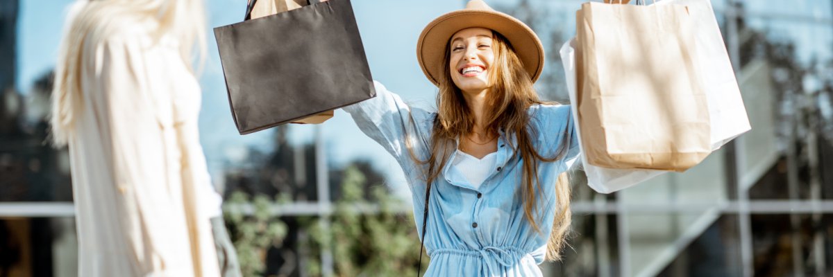 Two happy girlfriends walking with shopping bags in front of the shopping mall, feeling satisfied with new purchases Zwei glückliche Frauen mit Einkaufstüten